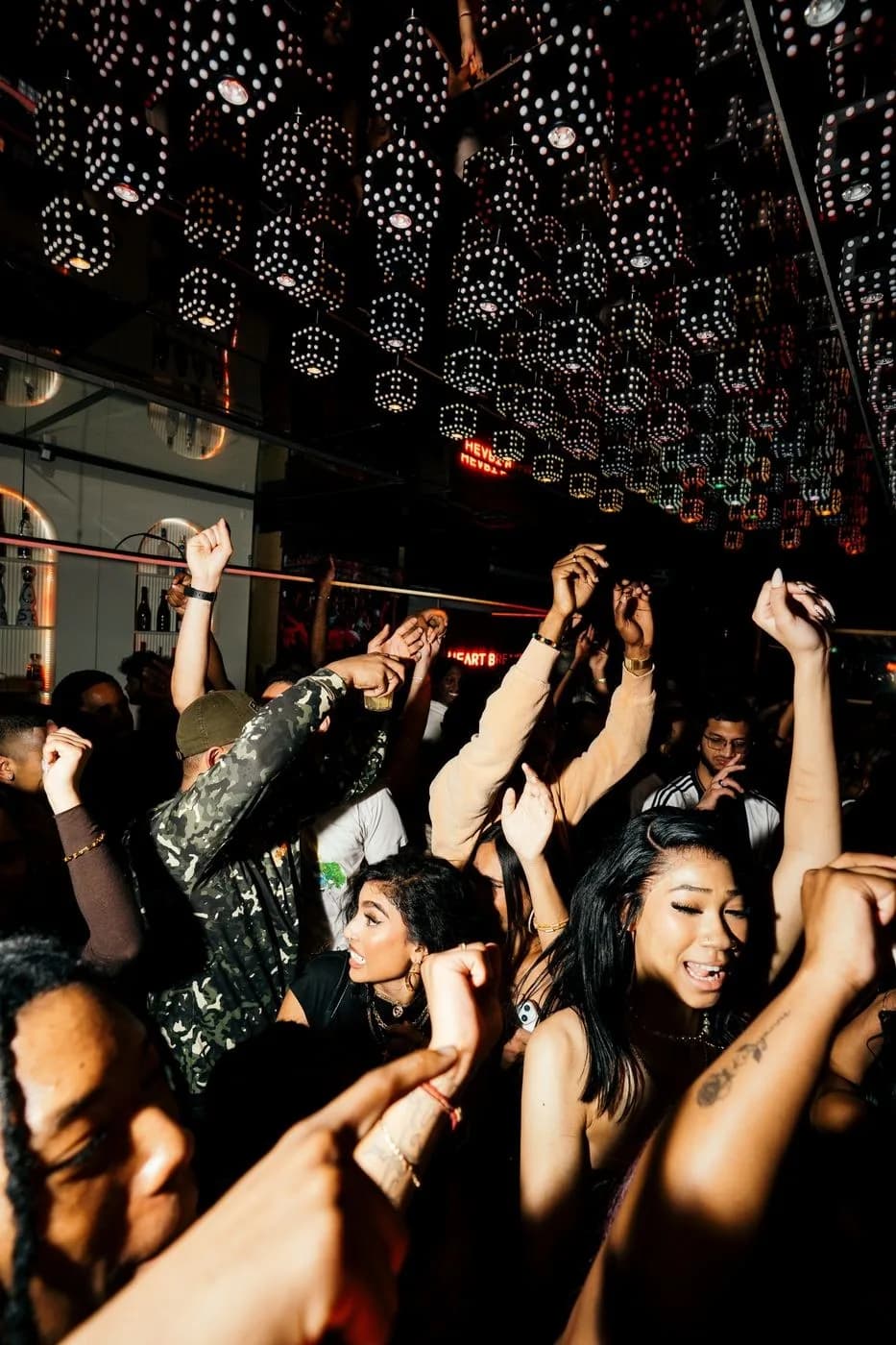 Crowd with hands up under a ceiling of glowing lanterns
